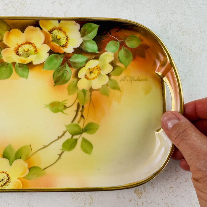 Right-hand side of antique yellow rose tray with hand for scale