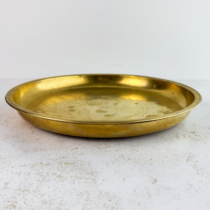 Three-quarter view of vintage engraved brass tray
