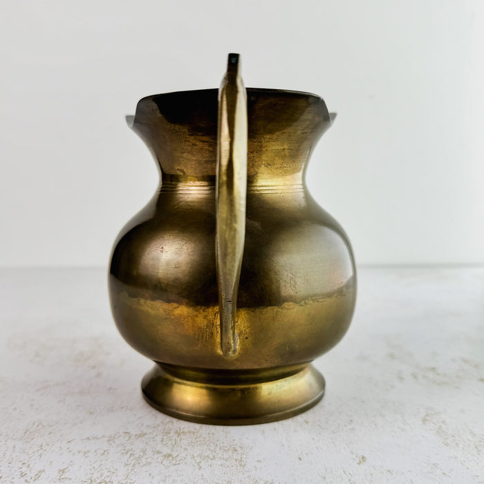 View of vintage brass pitcher with spout facing away