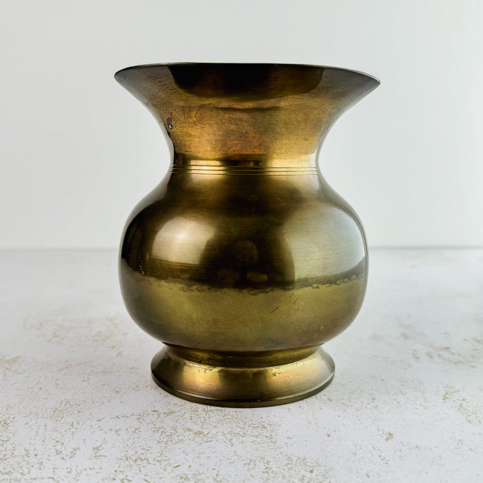 View of vintage brass pitcher with spout facing forwards