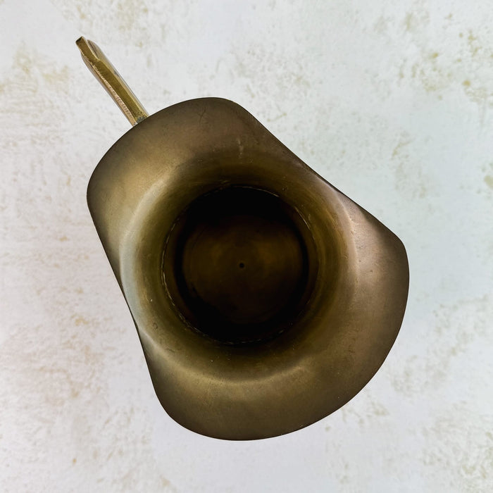 Top down view of vintage brass pitcher showing flared spout lip