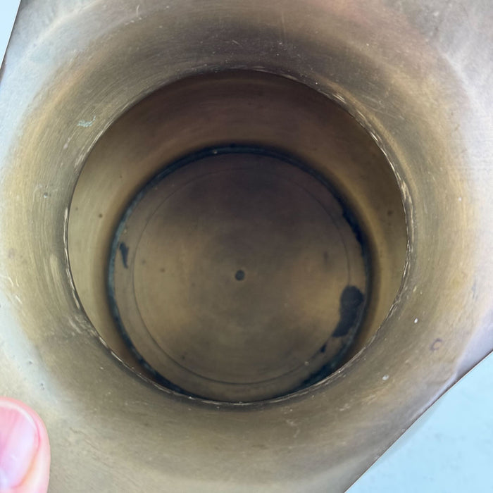 Close-up view inside the brass pitcher showing some dark areas