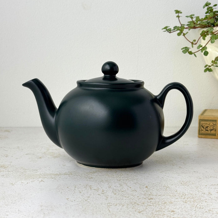 Matte black Pristine England teapot with rounded body, curved spout, loop handle, fitted lid, and ball finial
