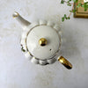 Vintage Gibsons Staffordshire England teapot viewed from above, showing the scalloped body, fitted lid, gold finial, spout, and handle.