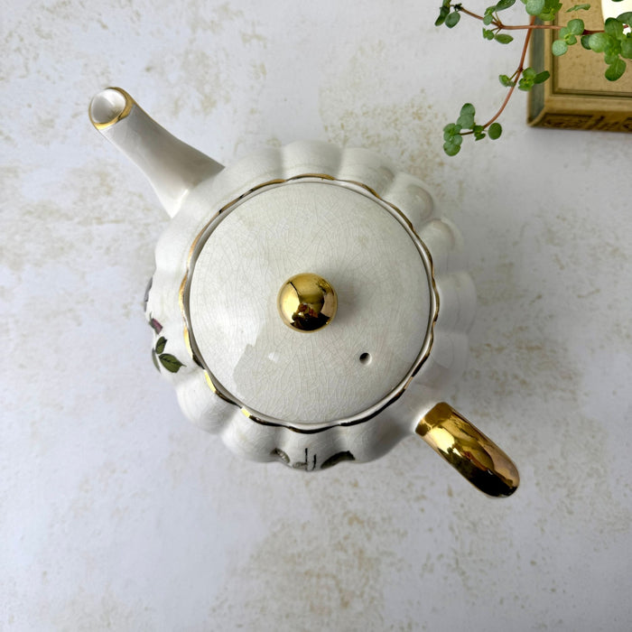 Vintage Gibsons Staffordshire England teapot viewed from above, showing the scalloped body, fitted lid, gold finial, spout, and handle.