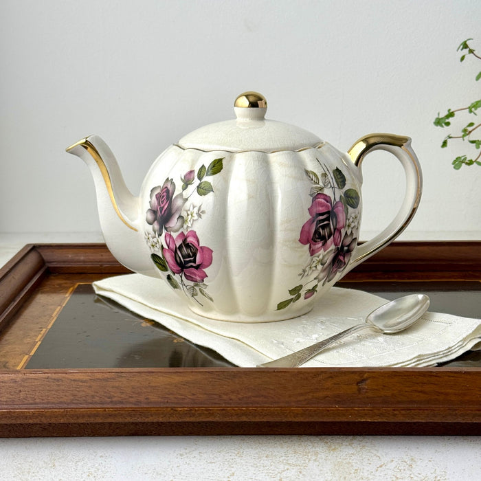 Vintage Gibsons Staffordshire England floral teapot styled on a wooden tray with a white linen napkin and silver spoon.