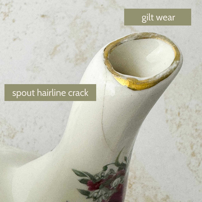 Close-up of the teapot spout showing a hairline crack and wear to the gilt rim with 'gilt wear' and 'spout hairline crack' text labels