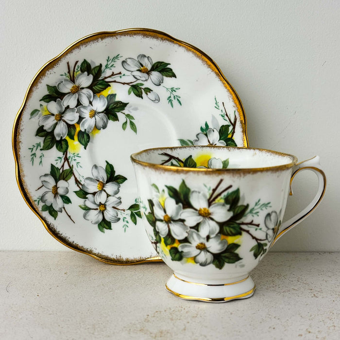View of Royal Albert White Dogwood saucer standing behind matching teacup