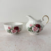 Royal Patrician fine bone china creamer and open sugar bowl, white ground with burgundy and pink rose transfer pattern and gold trim, swirl-ribbed form, Staffordshire England