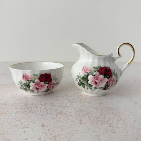 Royal Patrician fine bone china creamer and open sugar bowl, white ground with burgundy and pink rose transfer pattern and gold trim, swirl-ribbed form, Staffordshire England
