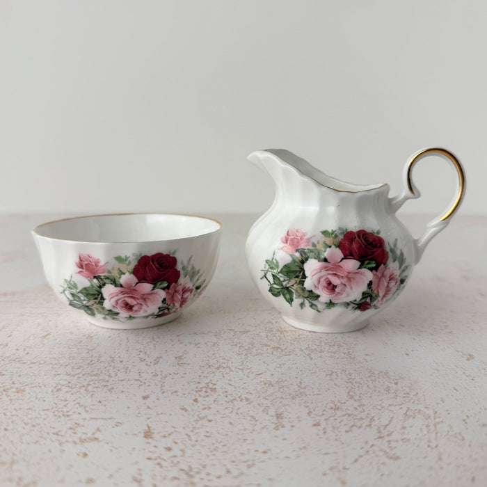 Royal Patrician fine bone china creamer and open sugar bowl, white ground with burgundy and pink rose transfer pattern and gold trim, swirl-ribbed form, Staffordshire England