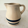 Side view of vintage stoneware pitcher with cobalt blue bands