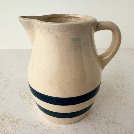 Side view of vintage stoneware pitcher with cobalt blue bands