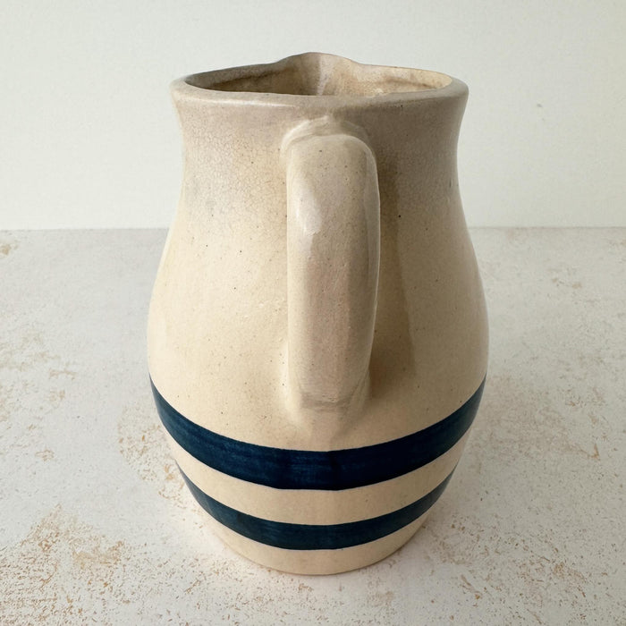 Handle side of vintage stoneware pitcher with cobalt blue bands