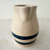 Spout side of vintage stoneware pitcher with cobalt blue bands