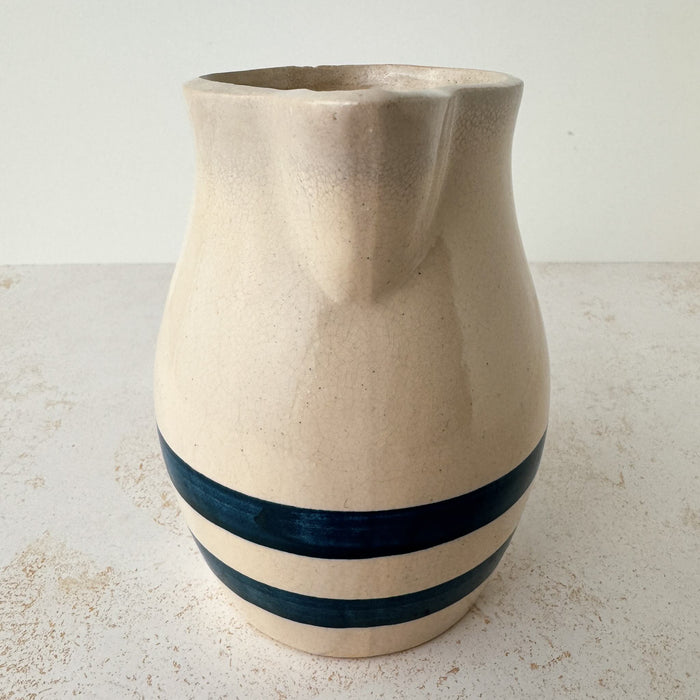 Spout side of vintage stoneware pitcher with cobalt blue bands