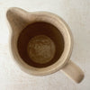 Top down view showing opening and interior of vintage stoneware pitcher with cobalt blue bands