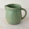 Side view of green Monmouth ribbed stoneware creamer