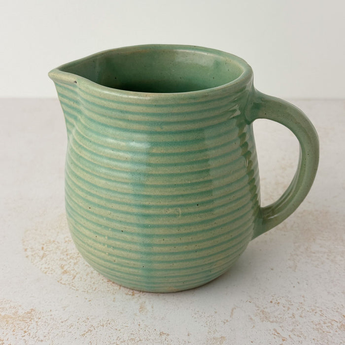 Side view of green Monmouth ribbed stoneware creamer