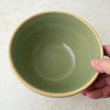 Hand holding Over and Back yellowware bowl