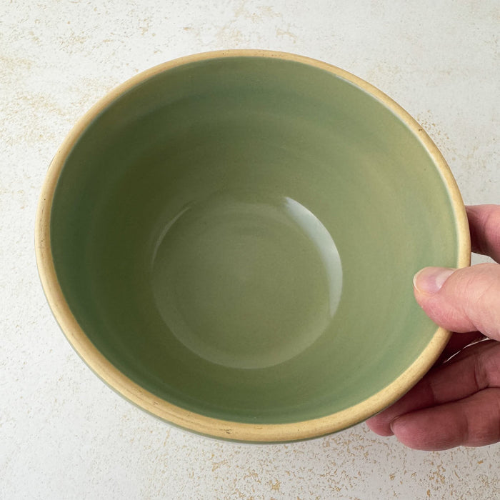 Hand holding Over and Back yellowware bowl