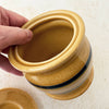 Hand holding rim of Park Designs yellowware canister