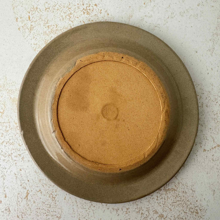 Underside of lid of vintage lidded stoneware crock with blue bands