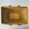 Top down view showing opening and interior of vintage lidded bamboo picnic basket with handles