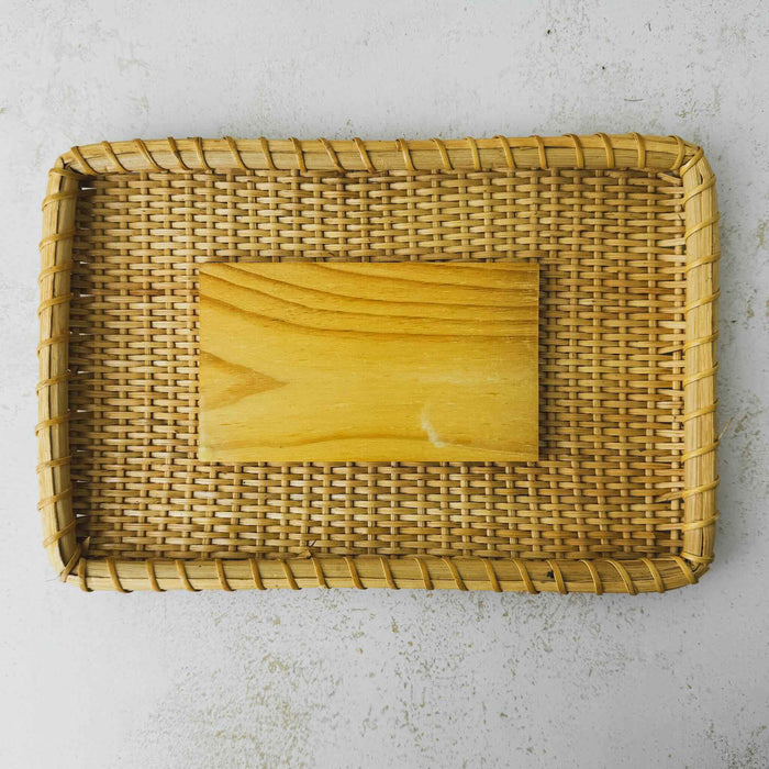 Underside of lid of vintage lidded bamboo picnic basket with handles raised