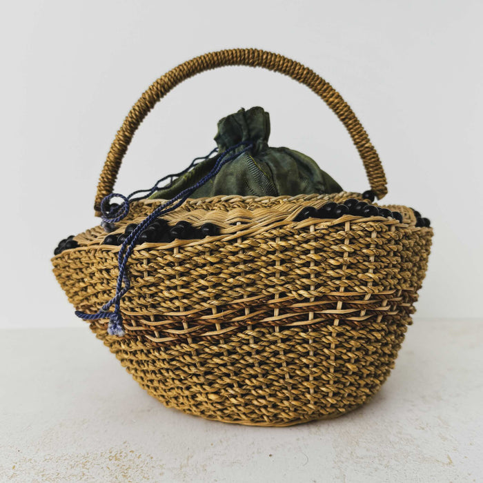 Front view of antique wicker vanity basket with beaded hexagonal form