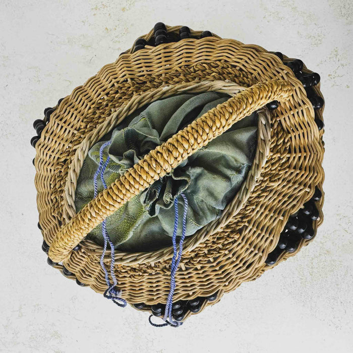 Top down view of antique wicker vanity basket with beaded hexagonal form