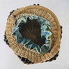 Top down view showing basket interior of antique wicker vanity basket with beaded hexagonal form