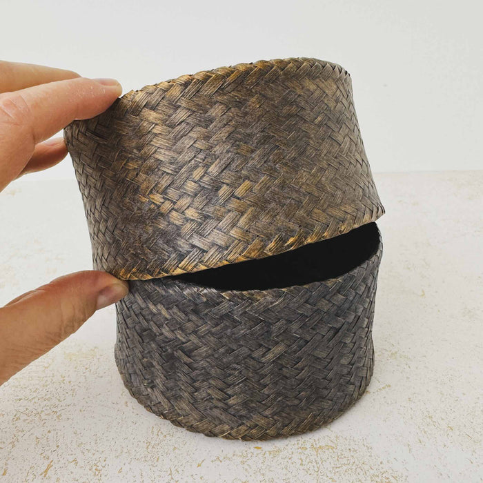 Hand lifting lid of vintage woven bamboo rice basket