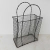 Different three-quarter view of vintage handwired basket with twisted handles against a light background