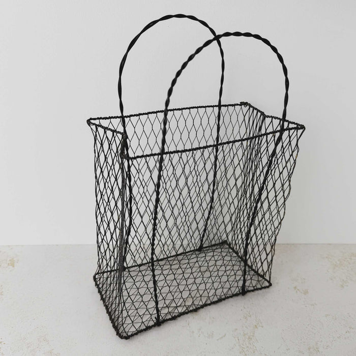 Different three-quarter view of vintage handwired basket with twisted handles against a light background