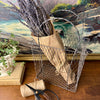 Vintage wire basket styled with kraft wrapped dried lavender, twine, and garden scissors on a wooden tabletop