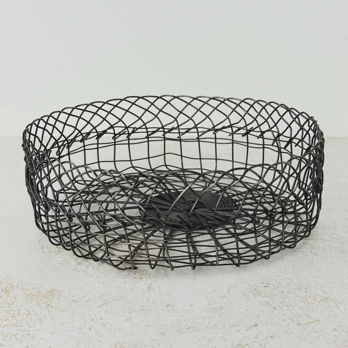 Three-quarter view of vintage handwired shallow round wire basket