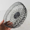 Hand holding vintage handwired shallow round wire basket