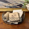 Vintage round wire basket used for organizing seed packets, garden notes, and twine on a wooden tabletop