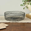 Vintage round wire basket styled with garden seed packets and trailing plant