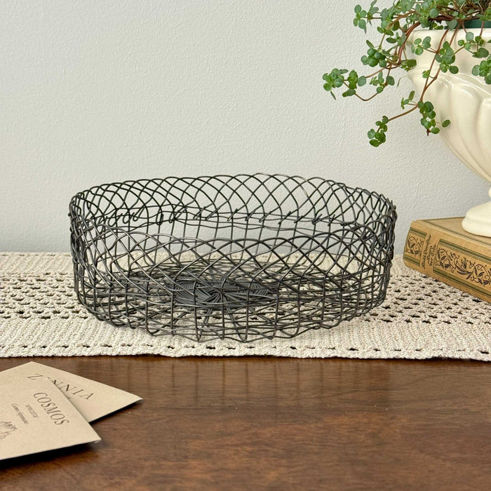 Vintage round wire basket styled with garden seed packets and trailing plant
