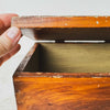 Hand lifting lid on antique primitive storage box with faux grain paint finish
