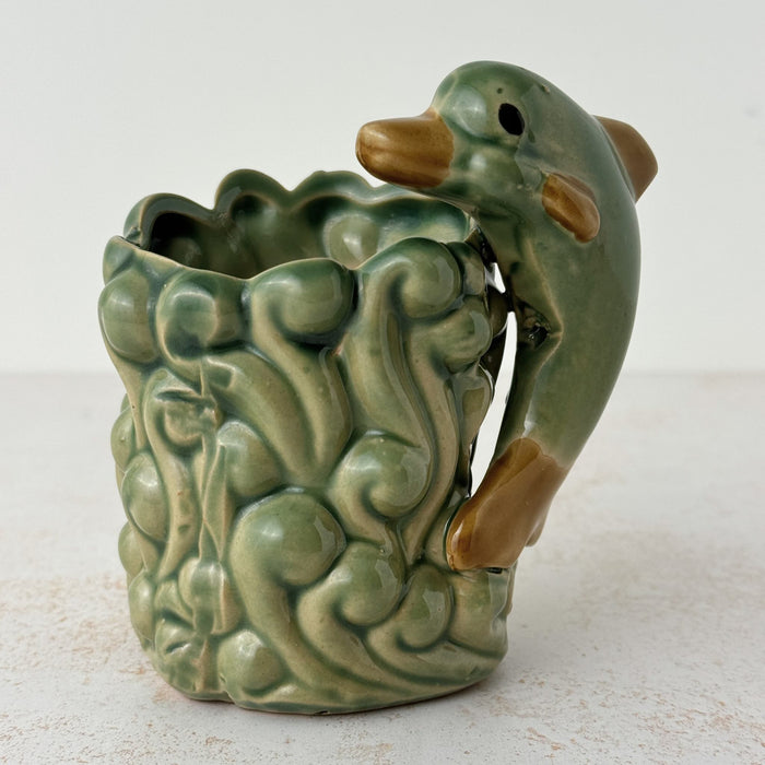 Front side of vintage majolica style dolphin planter