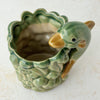 Angled top down view of vintage majolica style dolphin cachepot