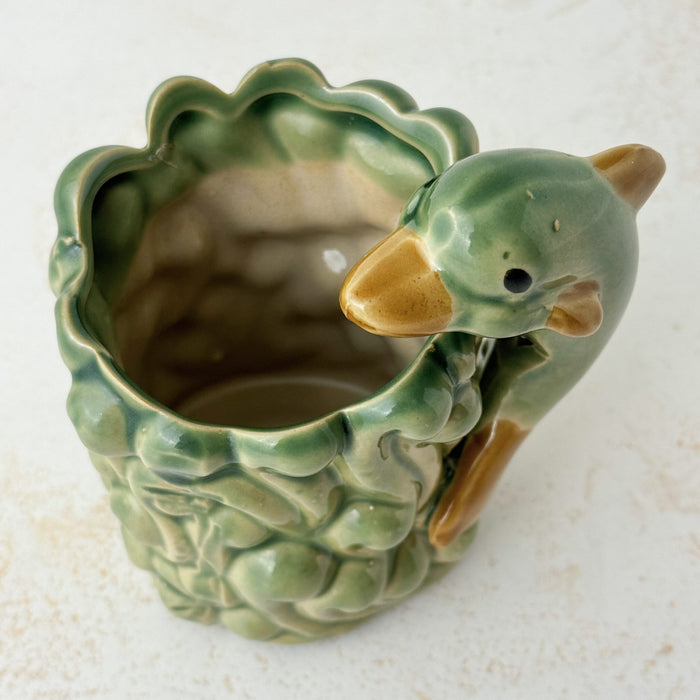 Angled top down view of vintage majolica style dolphin cachepot