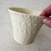 Hand holding rim of Lenox cachepot with embossed leaf design