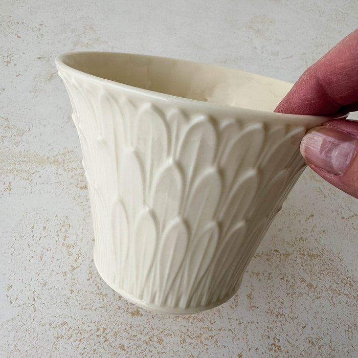 Hand holding rim of Lenox cachepot with embossed leaf design