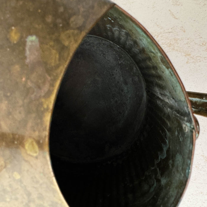 Top down close-up showing opening and interior of vintage brass indoor watering can