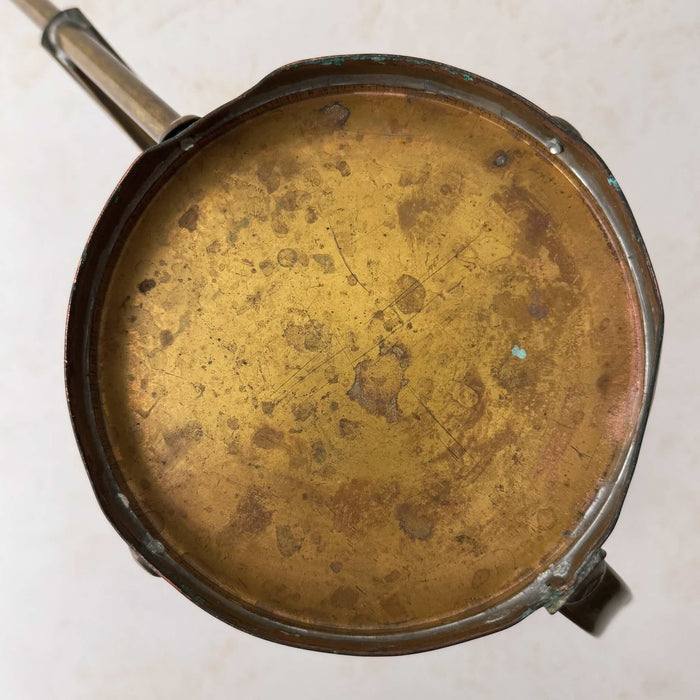 Bottom view of vintage brass indoor watering can with copper accents