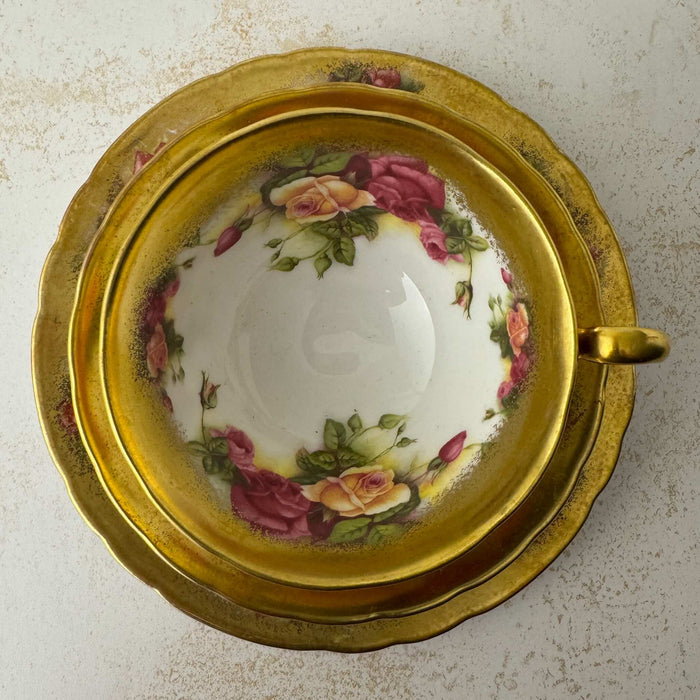 Top down view of Royal Chelsea Golden Roses teacup stacked on matching saucer and side plate